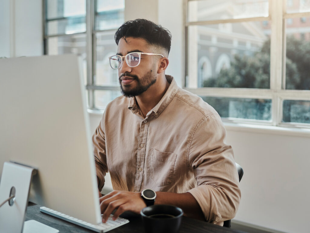 Information technology businessman working on computer in office for digital app, software development or website ux ui design. Young graphic designer with coding project or online company management