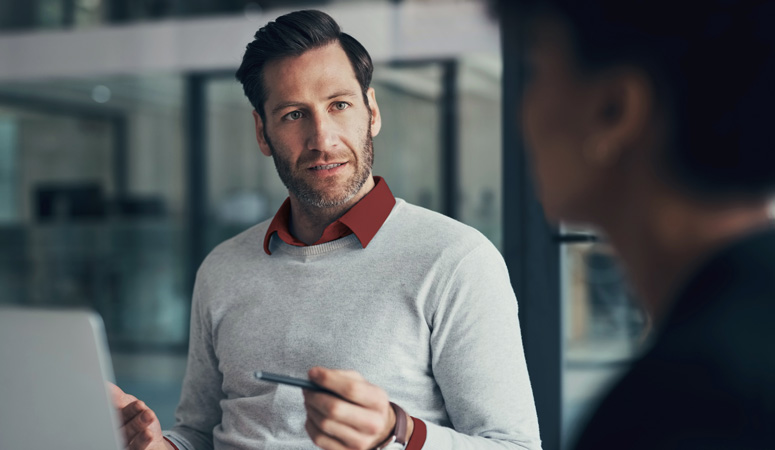An adviser in conversation with a client across a desk