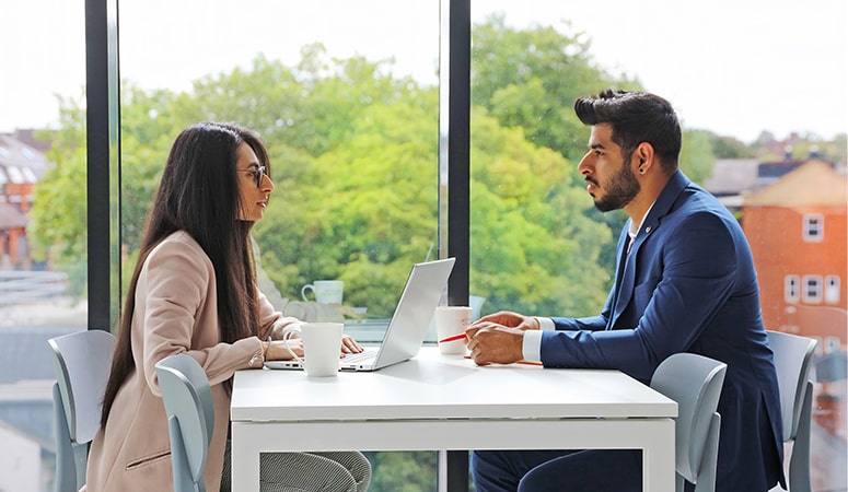 Man and woman talking at an office table