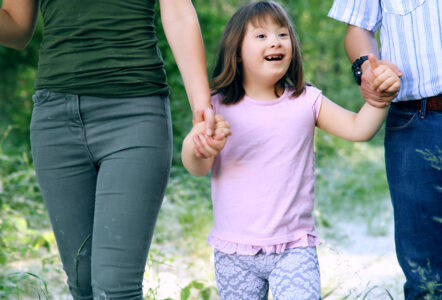 Little girl with walking with parents in nature