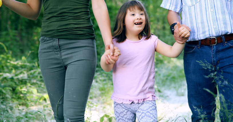 Little girl with walking with parents in nature