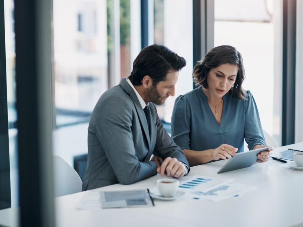 Business people, teamwork and tablet for statistics, finance report and planning of revenue, profit or sales in office. Professional advisor or clients with data analytics, graphs and digital charts