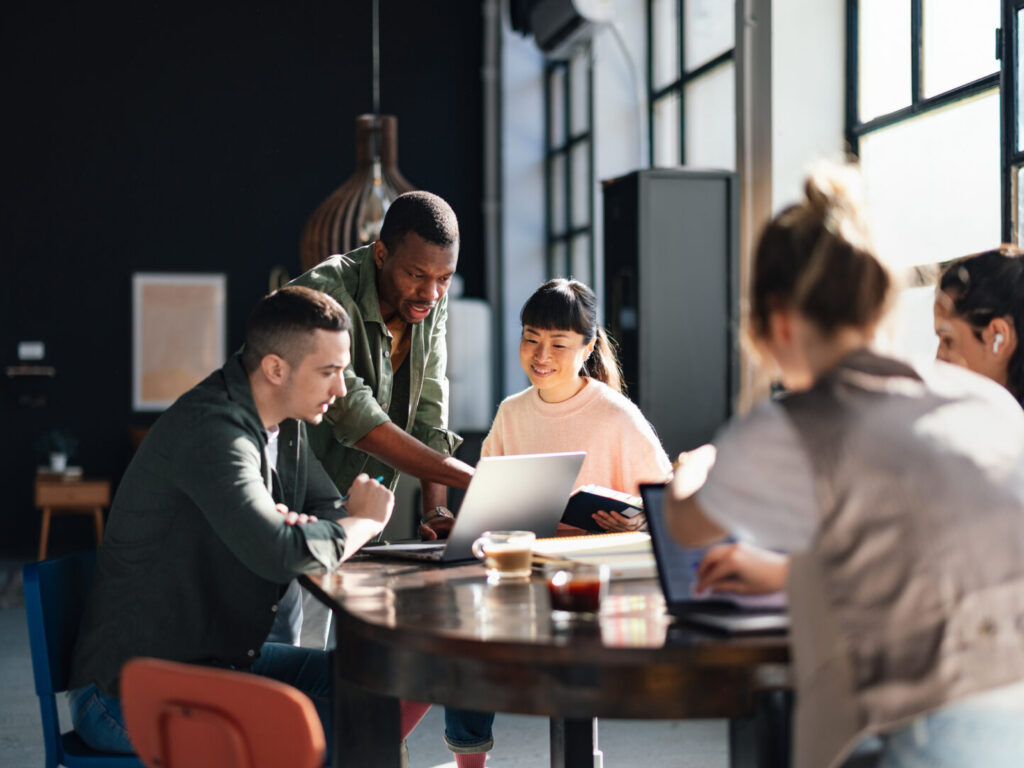 Young professionals or students collaborating in a bright, contemporary co-working environment, displaying teamwork and productivity.