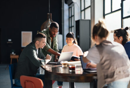 Young professionals or students collaborating in a bright, contemporary co-working environment, displaying teamwork and productivity.