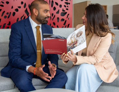 Two Mattioli Woods advisers discussing brochures together in an office