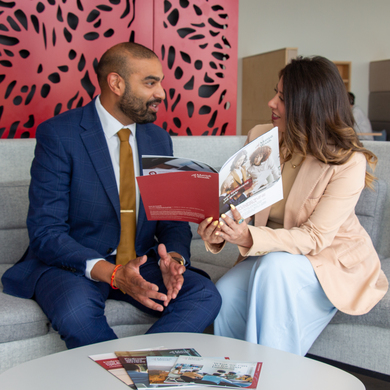 Two Mattioli Woods advisers discussing brochures together in an office