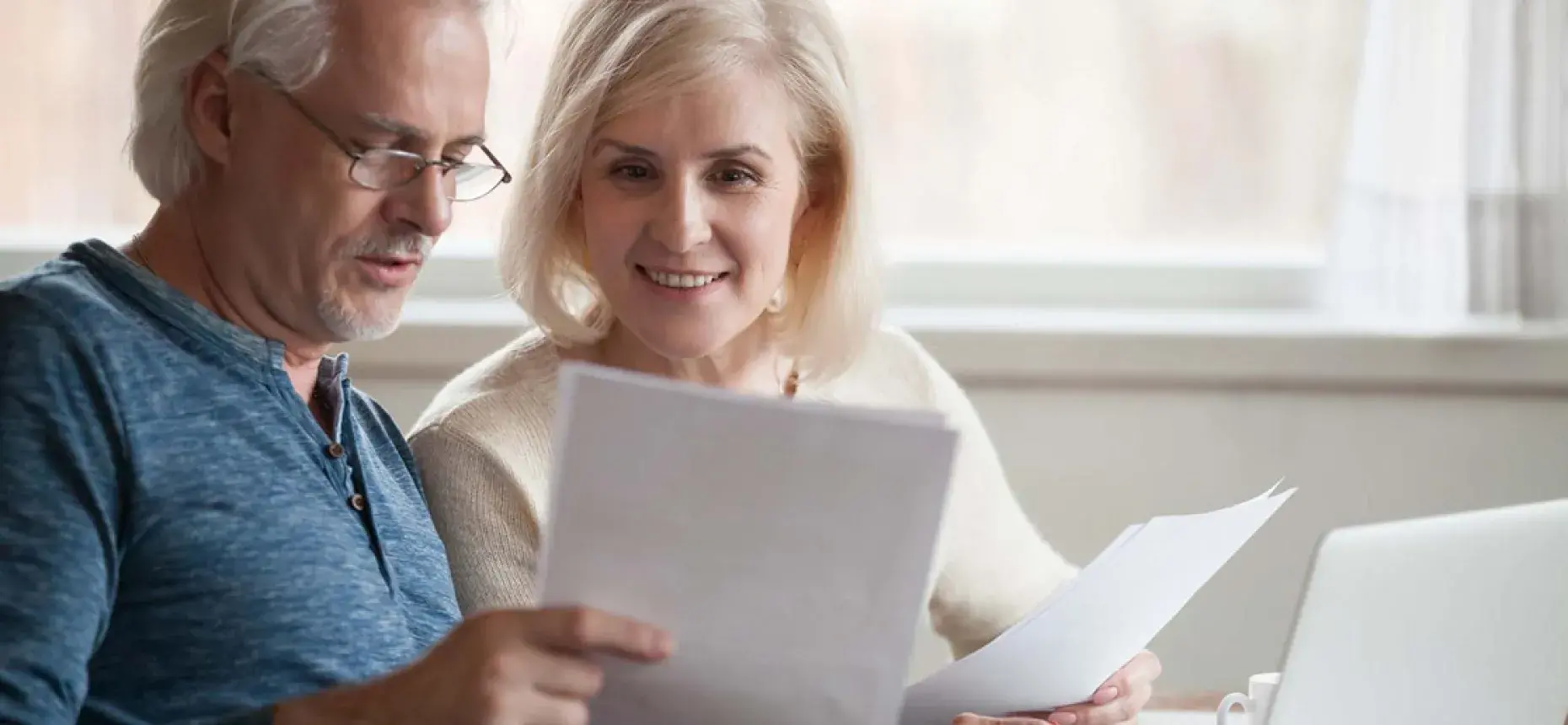 old couple looking at documents at home