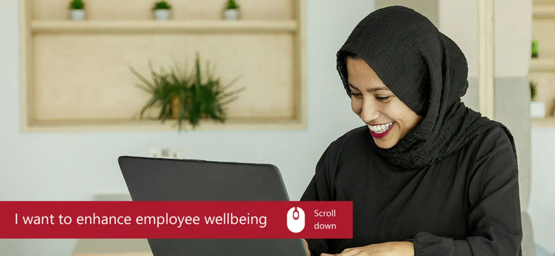 woman in hijab smiling looking at laptop