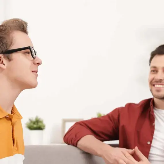 two men chatting on sofa 