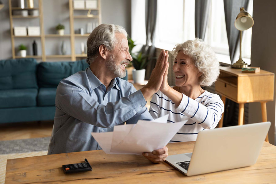 old couple hi fiving happy at home