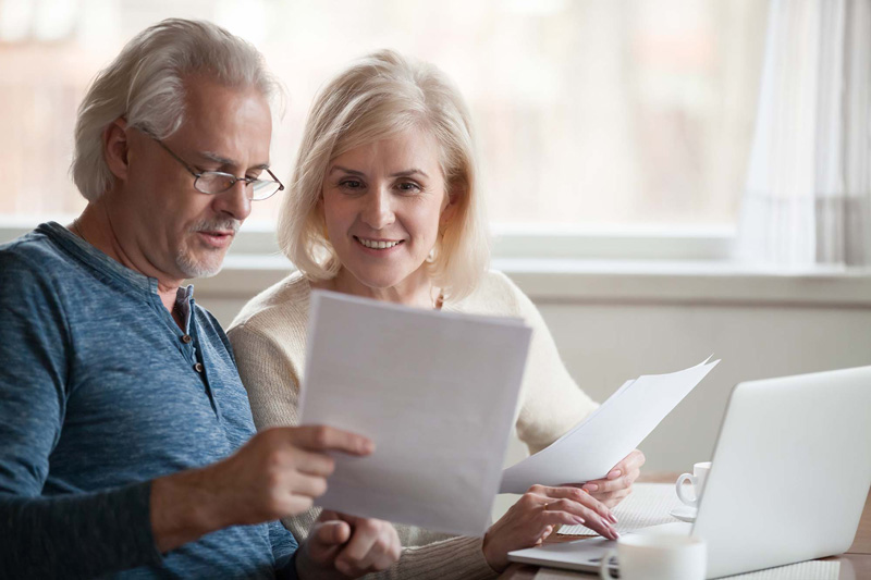 old  couple looking at documents at home